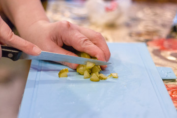 Obraz na płótnie Canvas Cut the cucumber into small pieces
