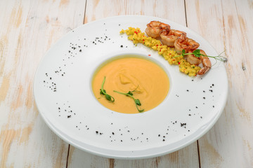 Creamy oil and spices soup, is served with shrimps