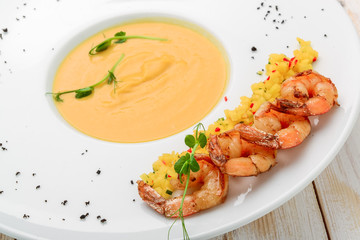 Creamy oil and spices soup, is served with shrimps