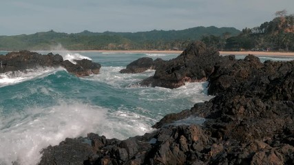 Slow motion shot of big sea waves crashing against the rocks. Waves crashing and hitting on the rocks at the sea. Palawan island, Philippines. Beautiful scenic nature landscape. S Travel concept.
