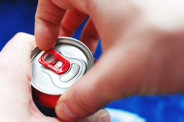 a man is going to open an aluminum can of beer, close-up