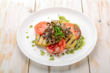 Grilled octopus on a plate.,grilled octopus with grilled vegetables