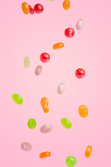 Caramel candy falling on a pink background, sweets and delicacies