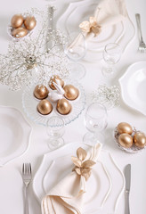 Happy Easter! Golden decor and table setting of the Easter table with white dishes of white color.