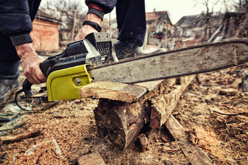 Sawing Wood Chainsaw. Dramatic Photo Processing Style.
