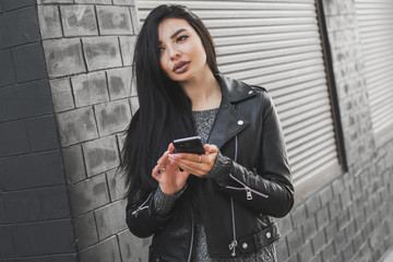 Beautiful woman using the phone on the street.