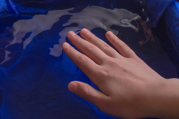 Children's hands against the background of water and white.