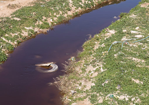 water pollution and trash are abundant in the nahal hevron stream near the cities of tel sheva and omer in the negev in israel
