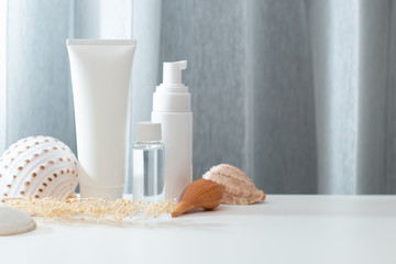 close up summer concept of spa sea beach beauty cosmetic body lotion cream aroma perfume sunscreen spf mockup package product with shell and flower on table