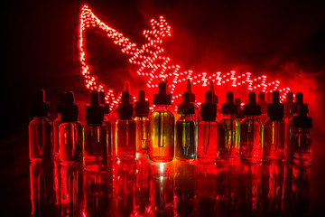 Vape concept. Smoke clouds and vape liquid bottles on dark background. Light effects. Useful as...