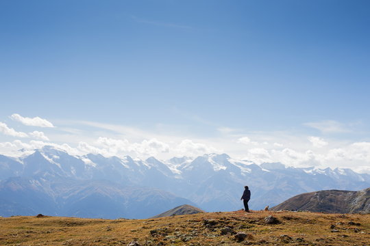 Woman standing on a cliff edge high up in the mountains