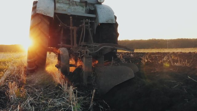 Rear view of an old gray tractor with a harrow