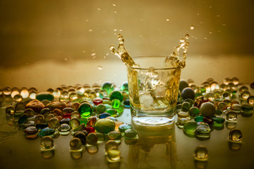 A Glass Of whiskey with ice and gold sunlight. Outdoor shot of whiskey with splash on sunset background.