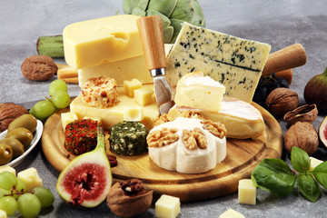 Cheese plate served with figs, various cheese on a platter on wood