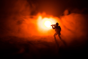 Military soldier silhouette with gun. War Concept. Military silhouettes fighting scene on war fog sky background, World War Soldier Silhouette Below Cloudy Skyline At night.