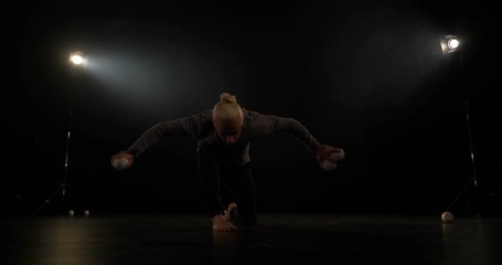 4k slow motion - juggler in the black studio make trick with one ball.