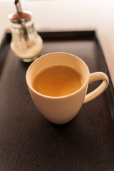 cup of coffee and sugar bowl over black surface.