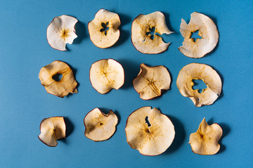 dried apples chips over blue background.