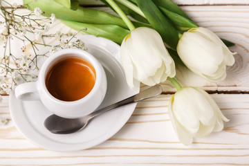 Spring tulips and coffee on a white wooden background, top view. Mother's day background, women's day, morning Birthday