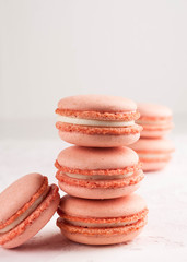 pink macarons in stack on white texutured background