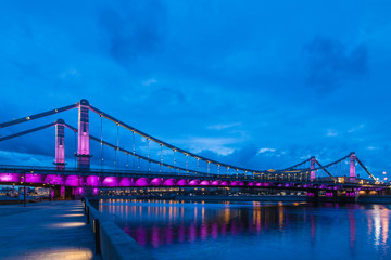 Krymsky Bridge or Crimean Bridge  across the Moskva river in Moscow in the rays of setting sun in the evening blue hour with illumination