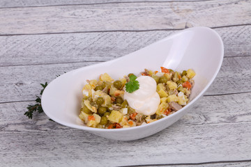 Traditional Russian salad with chicken in the white bowl