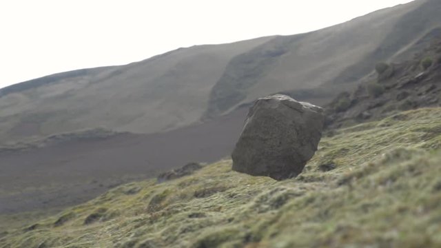 Big rock rolling down a steep hill in slow motion