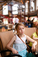 Blonde girl in white and blue dress having lunch in the restaurant