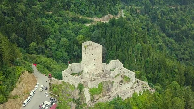 4K hd aerial drone ascending and bird look shot, over Zil Castle, a river inside green valley, a road neaby the castle, in Camlihemsin, Rize Province, Turkey