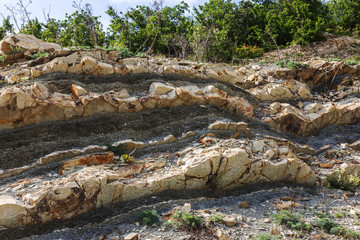 Fototapeta na wymiar Shale mountains cement pits. The texture of the stone wall. Large stone cracks, the separation of the stone ridge. Background of stone wall texture. Stone for construction cement production