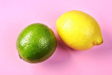 Fresh mixed exotic fruits lemon and lime on a pink background. Fruit background. Top View.