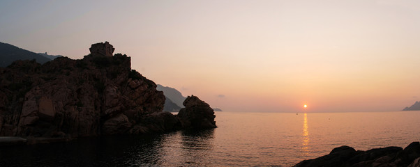 Sunset on the beach surrounded by mountains on the island of Corsica