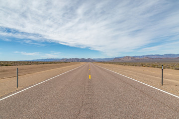 Looking along a long, straight road in the Nevada desert