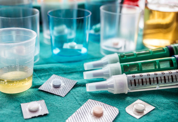 Diverse medication in glasses monodose along with insulin injectors in hospital, conceptual image, horizontal composition