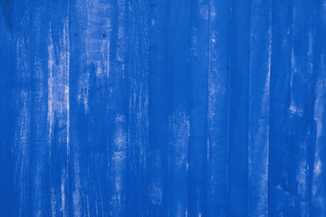 Blue painted uneven metal wall surface close up