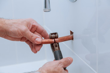 hand of working cutting copper pipe