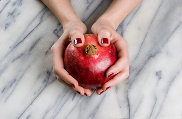 woman hands opening a pomagranate
