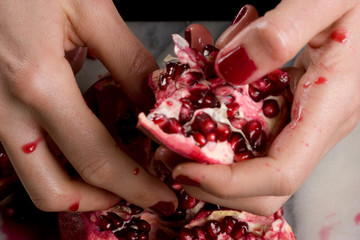 woman hands opening a pomagranate