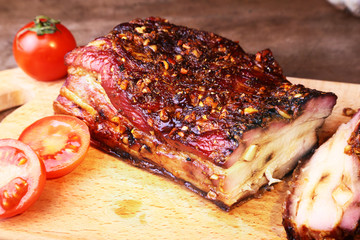 Sliced grilled pork ribs barbecue Striploin steak with chimichurri sauce and tomatoes on cutting board on dark background.