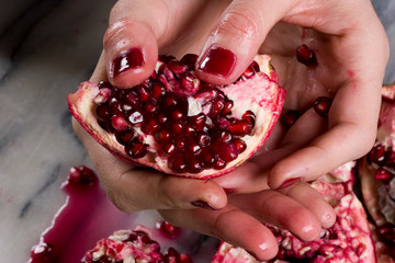 woman hands opening a pomagranate