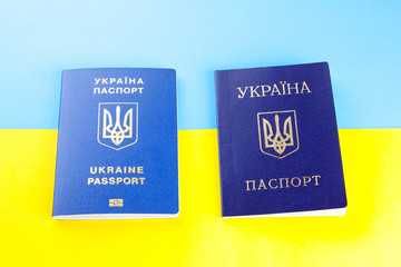 Ukrainian biometric passport and internal passport on background of the Ukrainian flag. Passport for traveling abroad on yellow blue background. Top view
