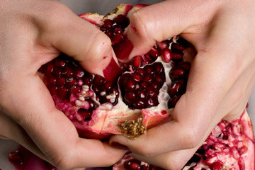 woman hands opening a pomagranate