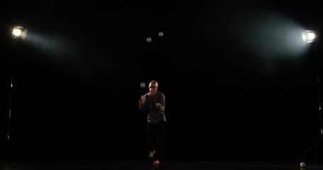 Juggler on the stage makes tricks with 9 ball and have a fail.