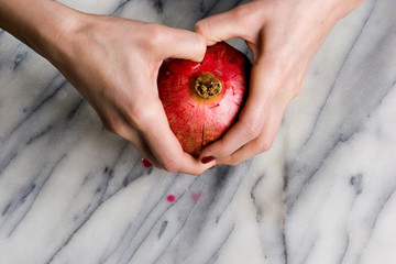 woman hands opening a pomagranate