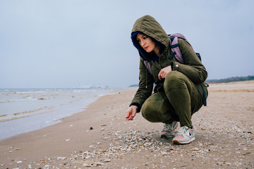 Kobieta zbiera muszle na plaży