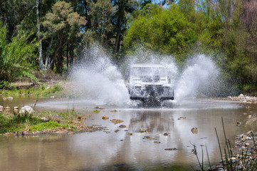 Rural Andalucia, Andalusia. Spain. 4x4 vehicle crossing river causing water splashes. Front view.