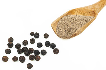 Close up heap of black pepper in wooden spoon, peppercorns and milled pepper powder isolated on...