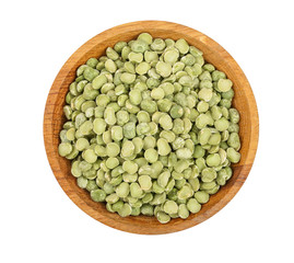 Green split peas in a wooden bowl isolated on white background. Top view