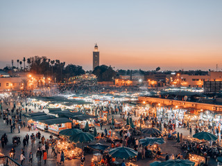 Djemaa el Fna - a famous market place in Marrakech, Morocco while sunset - obrazy, fototapety, plakaty
