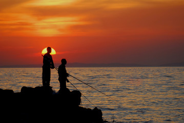 Fisherman on a shore at sunset